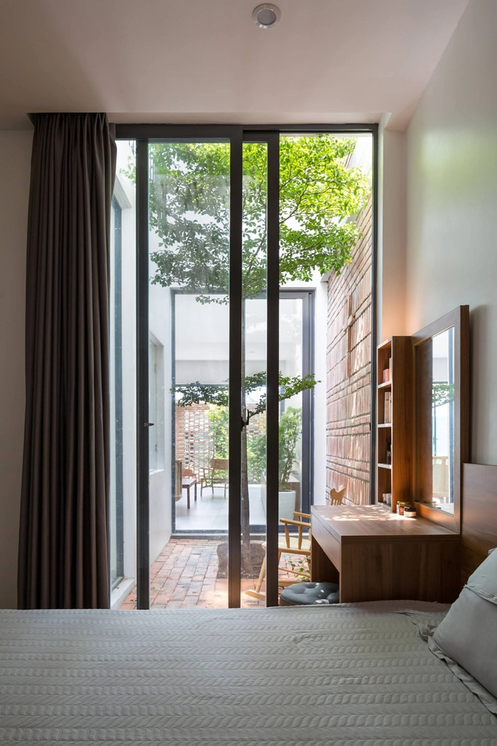 Phòng ngủ ở tầng 1 được thiết kế để tạo ra một không gian riêng tư nhất định, ngăn cách với những không gian khác bởi một khoảng vườn nhỏ. Ảnh: Hoàng Lê