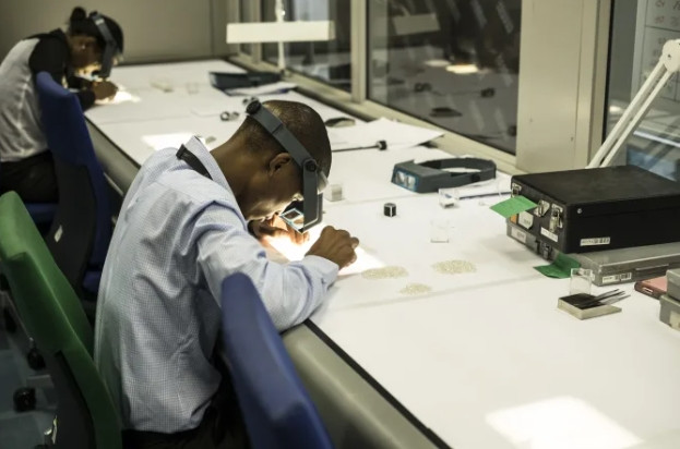 Công nhân đang kiểm tra kim cương thô trong xưởng của De Beers.