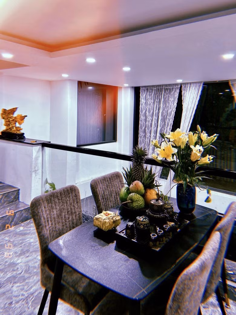 Bàn ăn giáp với cầu thang, có thể ngắm khung cảnh bên ngoài qua ô cửa.