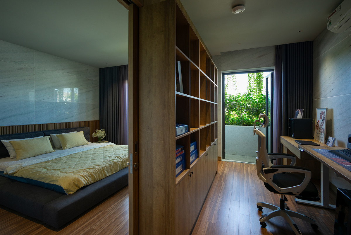 Tầng hai là phòng ngủ chính và phòng làm việc hướng ra ban công đón ánh sáng tự nhiên và gió mát.