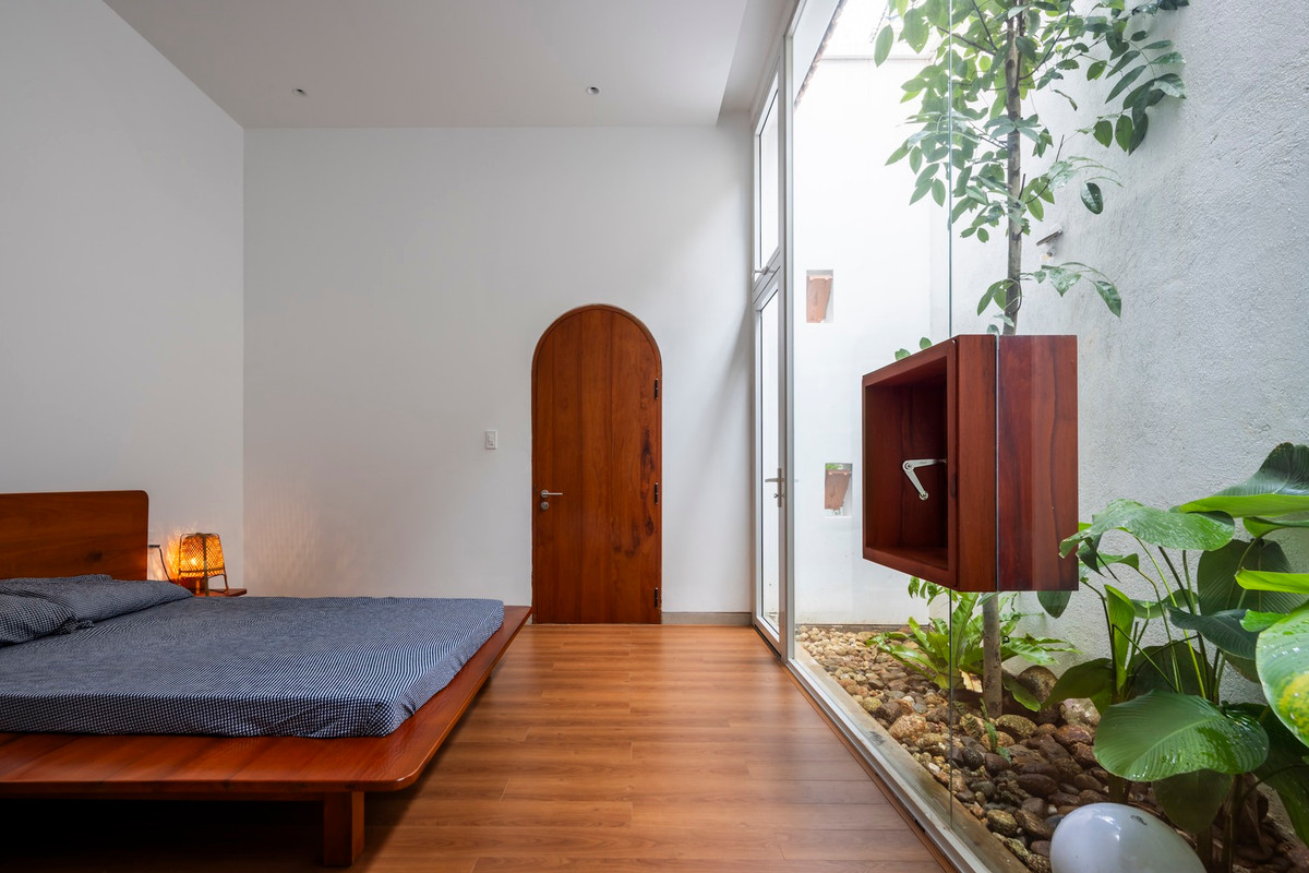 Phòng ngủ với tường kính giúp đón nắng và đem lại cảm giác thoáng đãng.