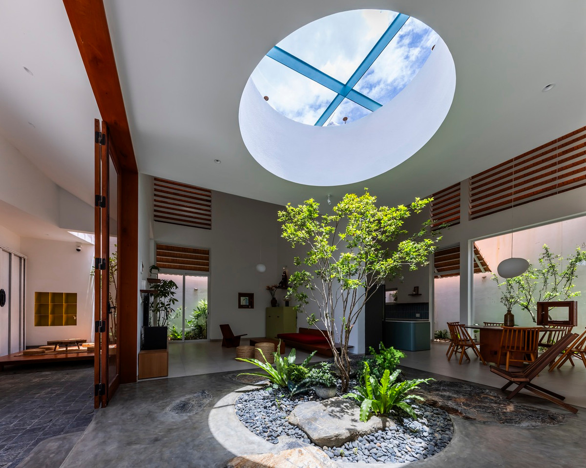 Khu vực giếng trời là trung tâm của không gian sinh hoạt chung tại tầng 1 với cây xanh và ánh nắng.