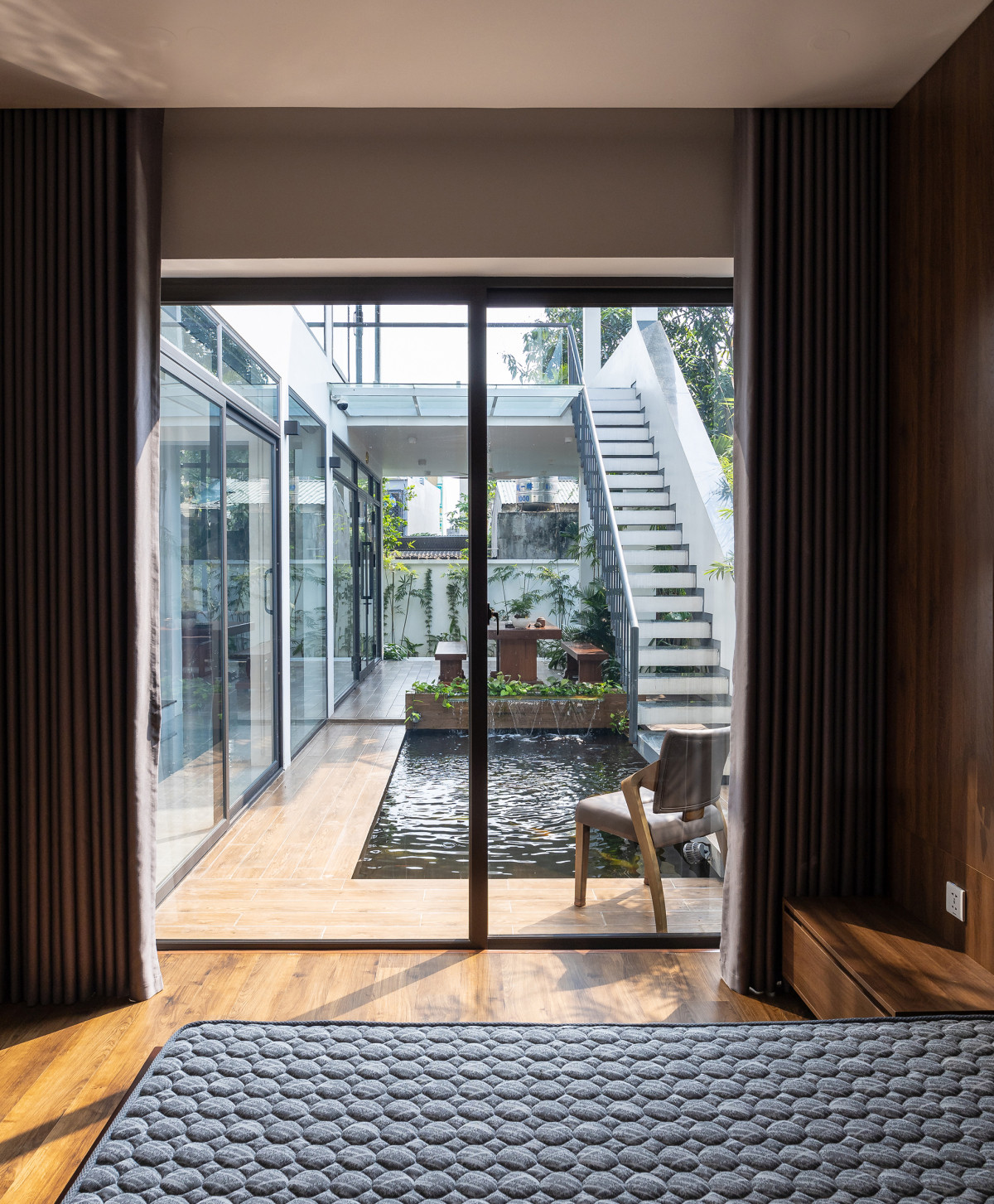 Phòng ngủ bố mẹ được bố trí sát hồ cá nhằm tận hưởng tối đa thiên nhiên, cây xanh, mặt nước.