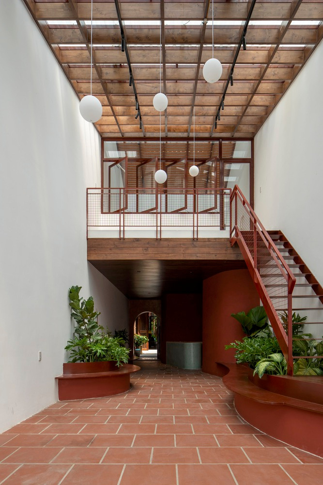 Do đó, kiến trúc sư tận dụng chiều dài lớn của khu đất để tổ chức các không gian theo trình tự tầng 1 gồm: cửa hàng cà phê - sân trong - phòng khách - bàn ăn - bếp - sân phụ - phòng ngủ. Ảnh: Hoang Le