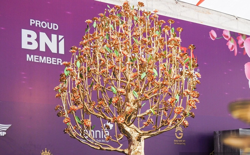 Tại một gian hàng hoa Tết khu vực Mỹ Đình (quận Nam Từ Liêm, Hà Nội), cây hoa đào dát vàng cao 2 m thu hút sự chú ý của đông đảo khách tham quan. Ảnh: Dân Việt