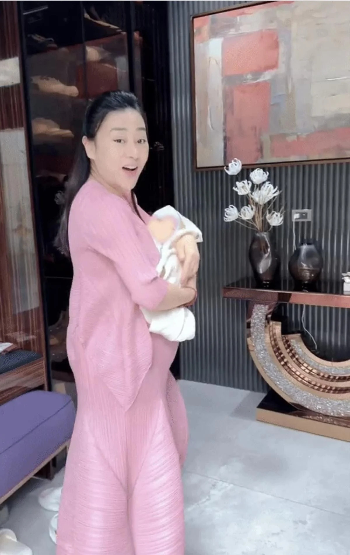 Bước vào nhà là sảnh chờ đơn giản với bức tranh nghệ thuật cỡ lớn và bàn trang trí hoa, sách tinh tế. Ảnh: FBNV