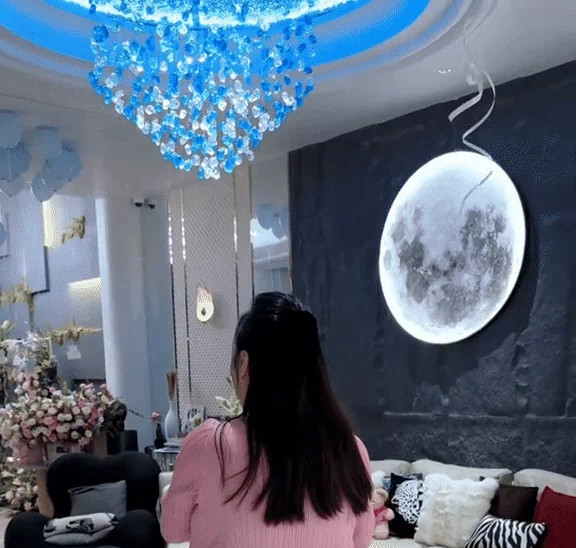 Điểm nhấn đặc biệt là đèn trang trí hình mặt trăng lớn trên tường và đèn chùm cao cấp, cho thấy sự tinh tế và đẳng cấp của gia chủ. Ảnh: FBNV