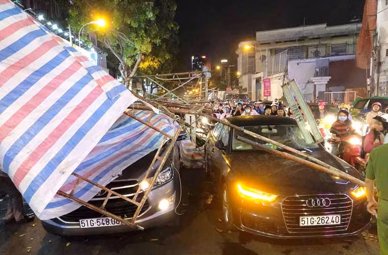 Khối giàn giáo đồ sộ đè lên 2 ô tô và 1 xe máy đang dừng chờ đèn tín hiệu tại khu vực nói trên.