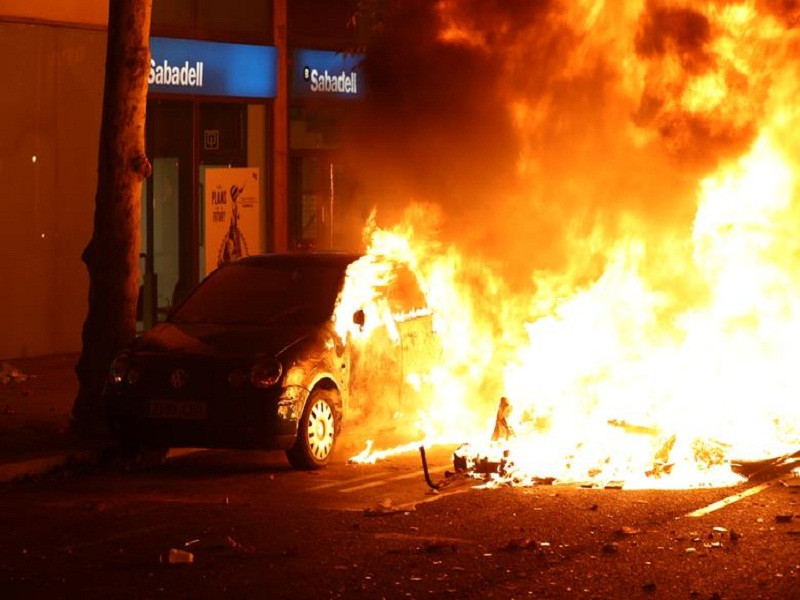 Chiếc ô tô chìm trong biển lửa trong cuộc biểu tình ở Barcelona.