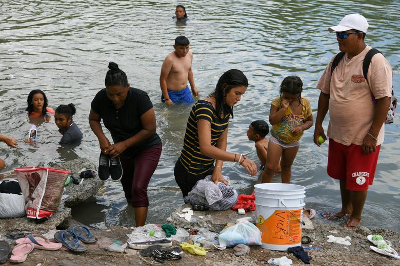 Nhiều người nhập cư tắm ở sông Rio Grande vì không có nước sinh hoạt trong khu trại ở Matamoros.
