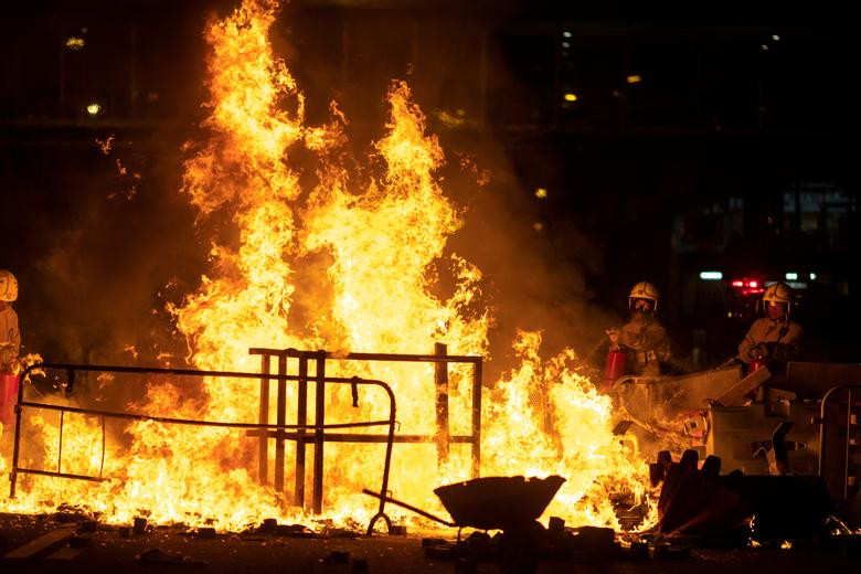 Lực lượng cứu hỏa dập tắt đám cháy do người biểu tình phóng hỏa trên đường phố ở quận Wong Tai Sin.