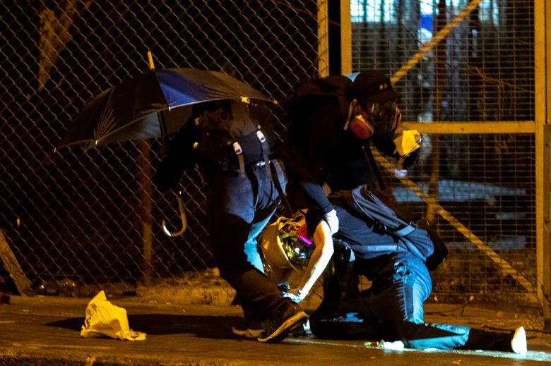 Một người biểu tình bị trúng đạn cao su được đồng đội hỗ trợ ở Wong Tai hôm 4/10.