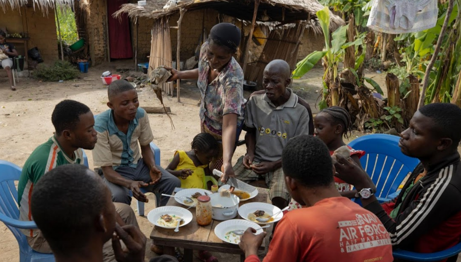 Ông Mohammed và các thành viên trong gia đình ngồi ăn thịt khỉ tại nhà ở Mbandaka.