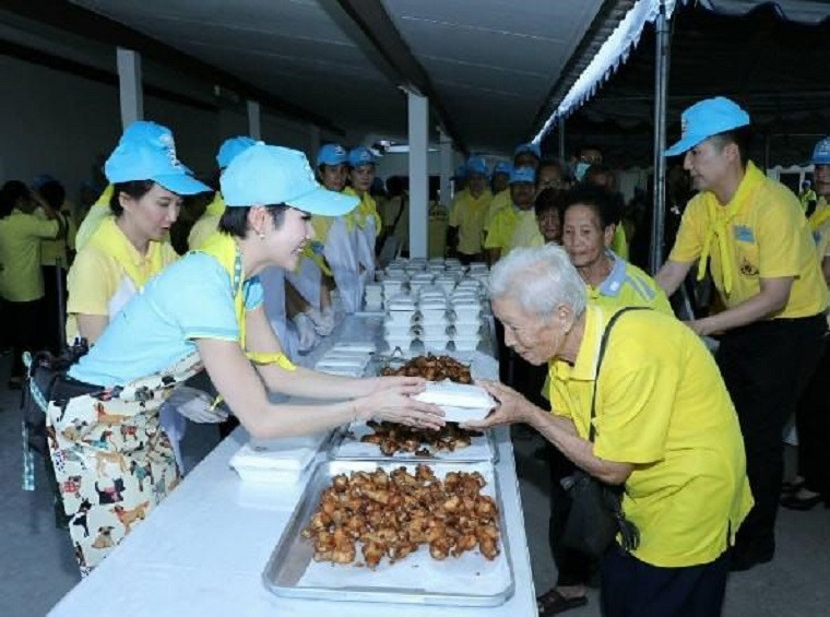 Bà Sineenat được nhìn thấy đeo tạp dề, xuống bếp nấu nướng với những người khác, tự tay phát những hộp cơm từ thiện cho người già. 