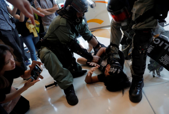 Cảnh sát chống bạo động Hong Kong bắt giữ một người biểu tình chống chính quyền ở Tsuen Wan ngày 13/10.