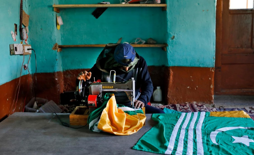 Mushtaq Wani, 35 tuổi, ngồi may vá trong nhà ở vùng Kashmir.