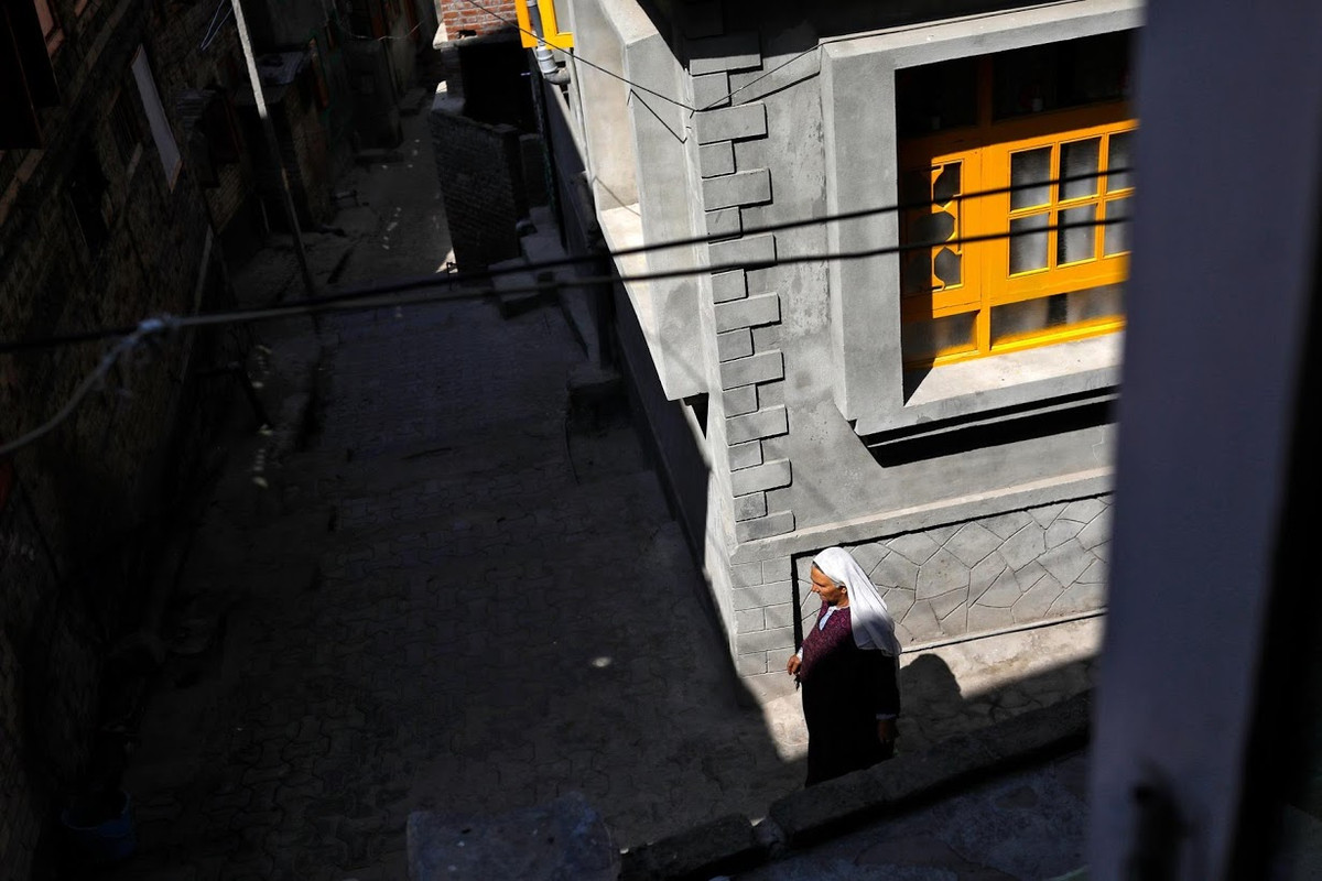 Người phụ nữ Kashmir đi qua con phố vắng vẻ ở Anchar.