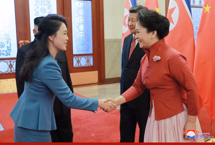Bà Ri Sol-ju (trái) bắt tay bà Bành Lệ Viện trong cuộc gặp hồi đầu năm. Ảnh: KCNA.