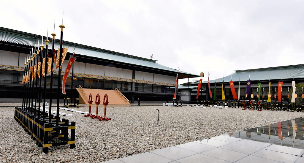 Khung cảnh tại Điện Seiden, nơi diễn ra nghi thức đăng cơ với sự chứng kiến của quan khách. Các quan khách được bố trí ngồi ở hai tòa nhà hai bên, trong khi nghi lễ diễn ra tại tòa nhà chính giữa.