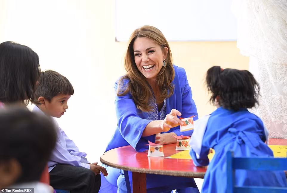 Công nương Kate Middleton cười tươi khi chơi một trò chơi với các em học sinh.