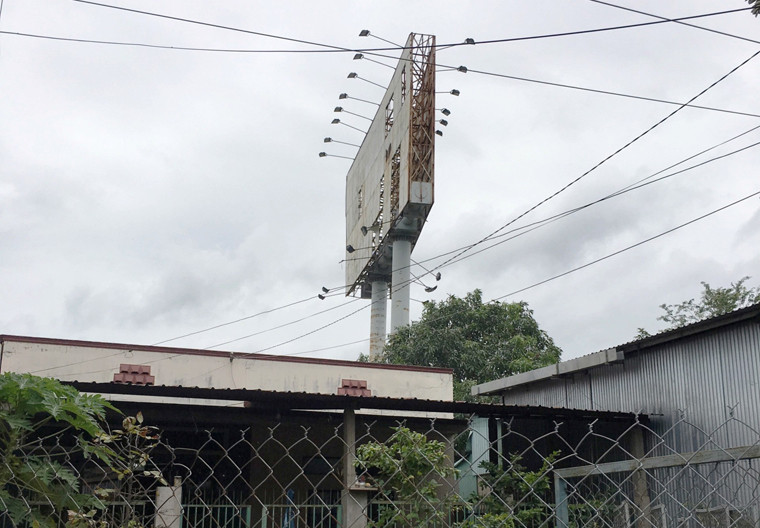 Một biển quảng cáo nằm giữa các nhà dân trên QL1A, đoạn qua huyện Bình Chánh, TP HCM.