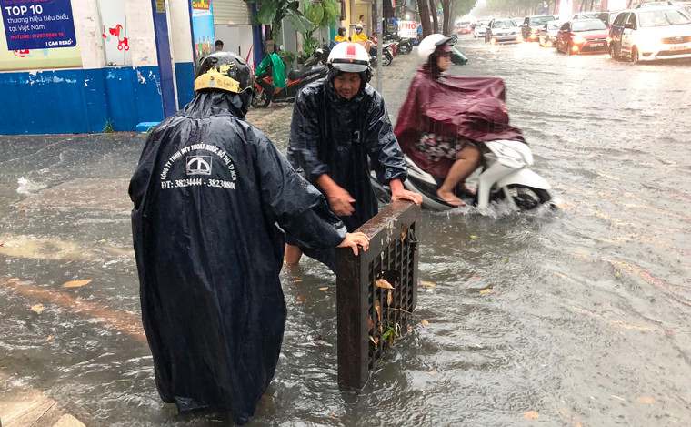 Công nhân Công ty thóat nước đô thị dầm mưa khơi thông cống rãnh.