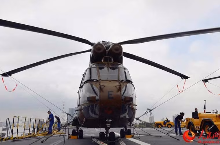 Theo thiết kế, tàu đổ bộ Mistral có thể chở tới 16 trực thăng hạng nặng hoặc 35 trực thăng hạng nhẹ. Trên boong có 6 điểm cất hạ cánh cho trực thăng cùng lúc. Ảnh: phóng viên Trung Quốc chụp ảnh trực thăng hải quân trên boong tàu Dixmude.