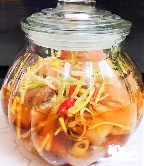 Xếp móng giò vào lọ thuỷ tinh, rồi đổ hỗn hợp nước ngâm lên, đến khi ngập nước trên chân giò. Bạn ngâm khoảng 1-2 ngày là có thể dùng được. Ảnh: Khám phá.