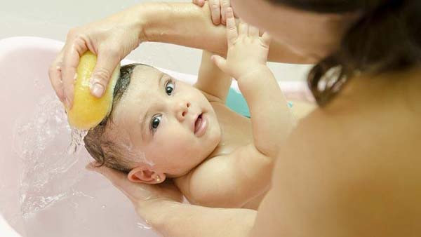 Để làm sạch thóp đúng cách, bác sĩ khuyên nên dùng một chiếc khăn mềm, làm ẩm bằng nước ấm rồi nhẹ nhàng vuốt quanh vùng thóp. Tuyệt đối không ấn hay gãi khi thao tác.