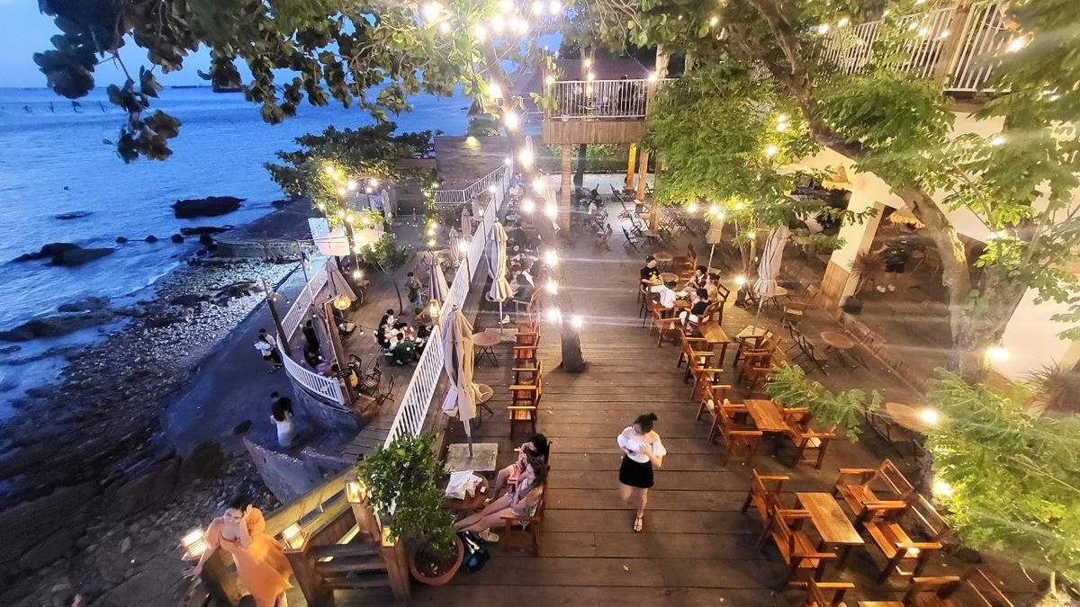 Du khách vừa ngắm mặt trời cuối ngày, vừa nghe sóng vỗ ngay chân mình.