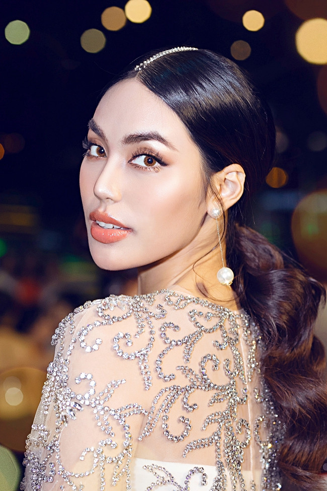 Bên cạnh đó, mái tóc chẻ ngôi giữa kết hợp hợp phần đuôi uốn xoăn, cột gọn gàng mang đến vẻ ngoài lạ mắt nhưng không kém phần ấn tượng.