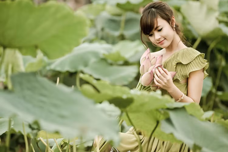 Giữa đầm sen vào mùa hạ, hot girl Midu nổi bật bởi nét đẹp trong sáng và thánh thiện. Ảnh: Dân Việt