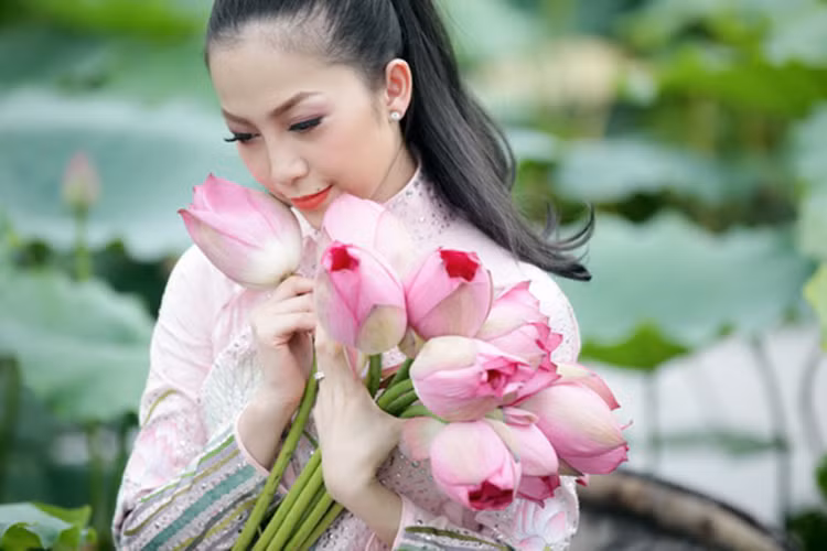 Diện áo dài tạo dáng bên hoa sen, diễn viên múa Linh Nga khoe vẻ đẹp truyền thống ngọt ngào, đằm thắm. Ảnh: Lao động