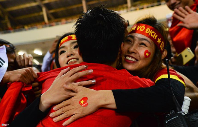 Tại giải AFF Cup 2018, trong giây phút lịch sử khi đội tuyển Việt Nam giành được ngôi vô địch, việc đầu tiên Duy Mạnh làm là tìm kiếm hình bóng bạn gái giữa biển người trên khán đài. Hình ảnh nam hậu vệ chạy đến, ôm Quỳnh Anh và Huyền Trang - chị gái của mình - vào lòng rồi đeo chiếc huy chương vàng cho bạn gái không khỏi gây xúc động. Ảnh: Việt Hùng.