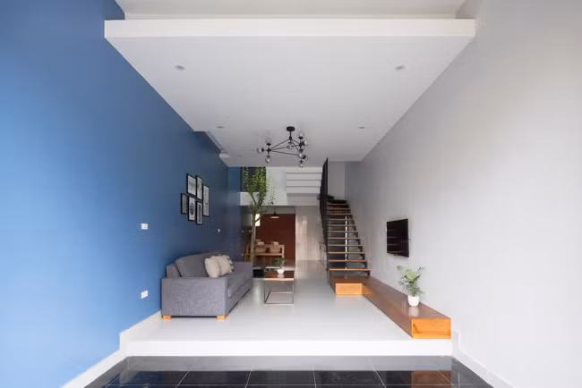 Phòng khách và chỗ để xe được phân biệt bởi màu sàn nhà, đồng thời phòng khách được nâng lên cao hơn 1 bậc, giải quyết triệt để vấn đề về vệ sinh.