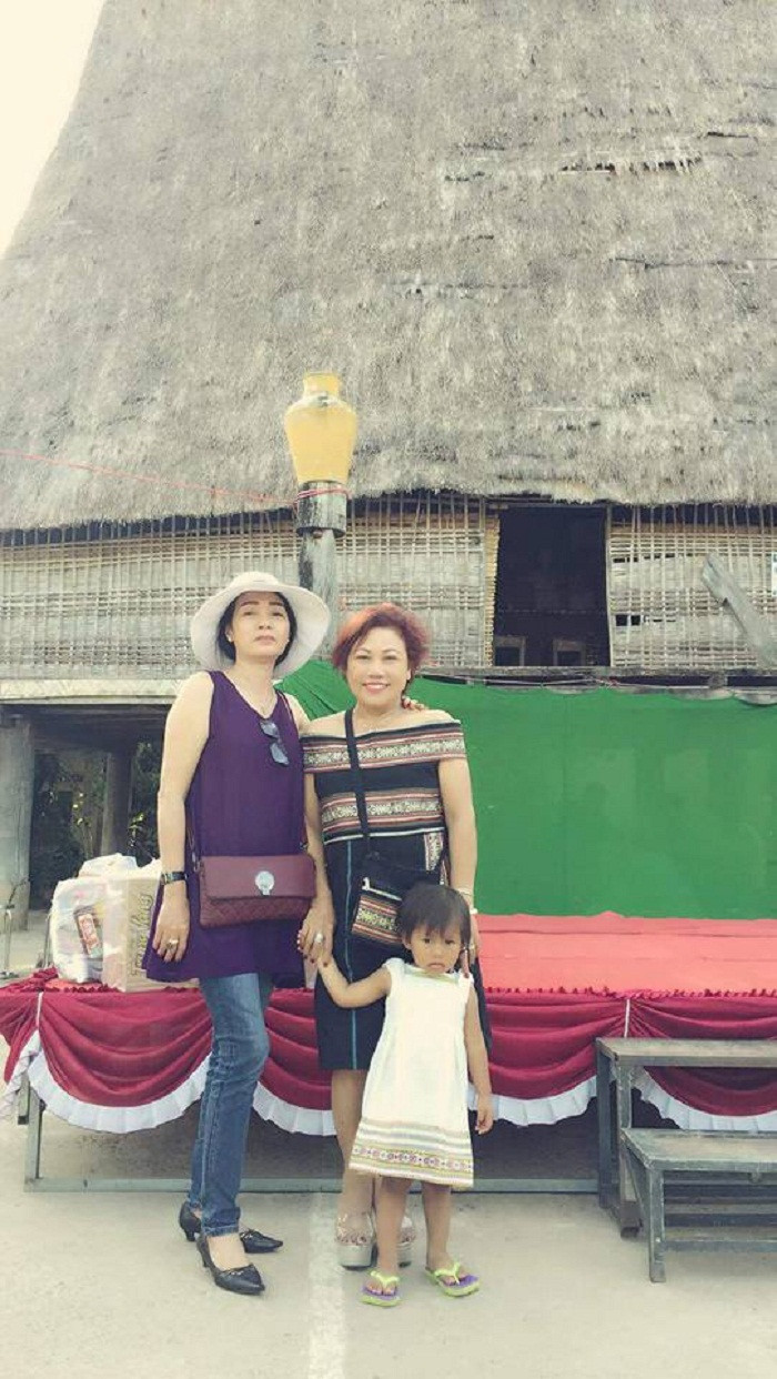 Siu Black chụp ảnh trước căn nhà Rông ở ngôi làng mà chị đang sinh sống.