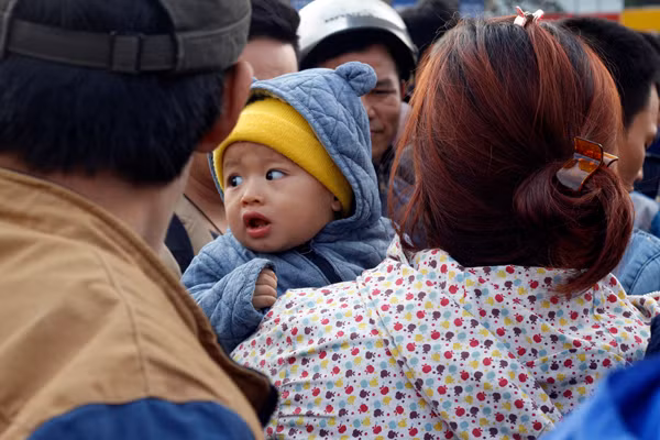 Em nhỏ khóc thét trong khi người mẹ cuống quýt chạy theo một nhà xe chạy tuyến Mỹ Đình - Thái Bình nhưng xe không bắt khách.