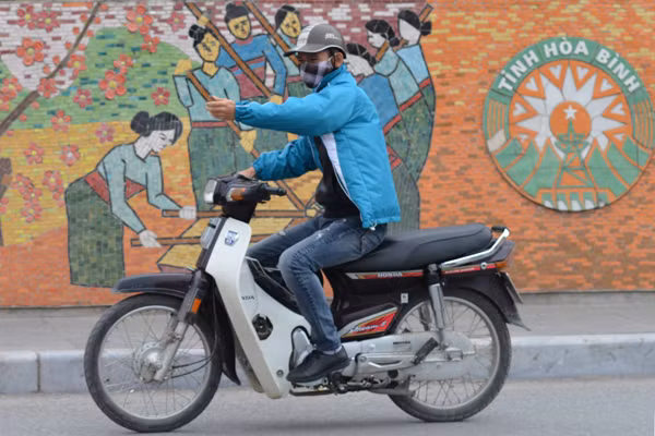 Bức ảnh ngẫu nhiên khác chụp lại nam thanh niên đi xe máy giơ tay về phía trước nhưng trùng hợp với một vật dụng lao động của người dân đang hăng say làm việc.