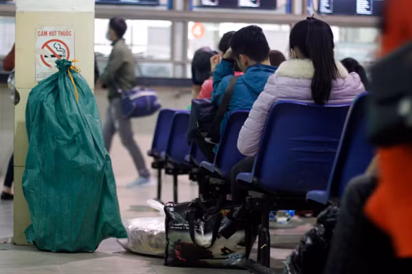 Một số người khác tranh thủ để đồ đạc xuống ngồi nghỉ tại ghế trong nhà chờ.