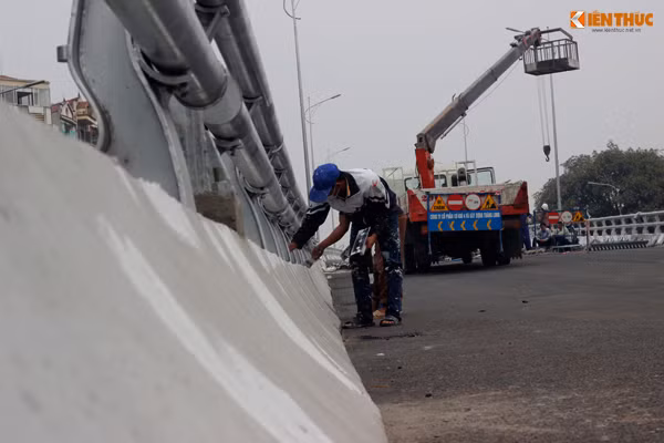 Công nhân nhanh tay phủ nốt lớp sơn lên các chỗ ở thành, tường cầu.