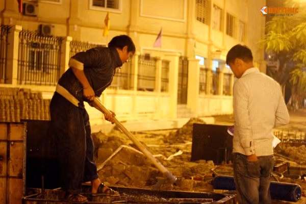 Hai thợ xây miệt mài với công việc ngoài trời lạnh với đôi bàn tay trần trên đường Võ Chí Công. Thỉnh thoảng cơ thể họ run rẩy do gió lạnh thổi qua.