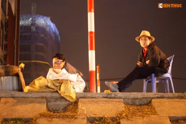 Phải ngồi co ro ở đê Nghi Tàm (Hà Nội) nhưng hai người bán ngô luộc vẫn nở nụ cười thật tươi chào mời khách mua hàng.