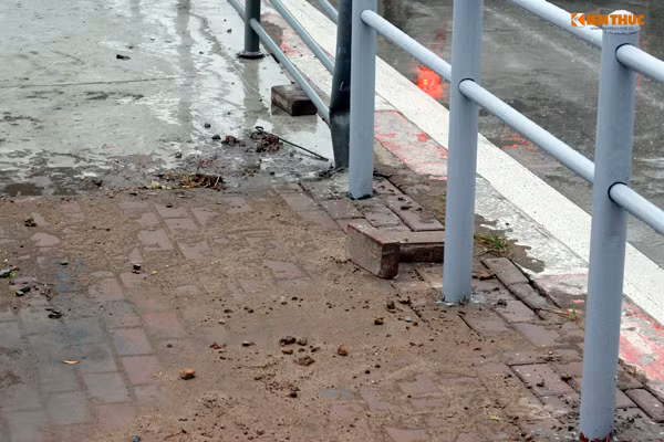 Vật liệu xây dựng vẫn còn lộn xộn trước cửa nhà chờ xe buýt.