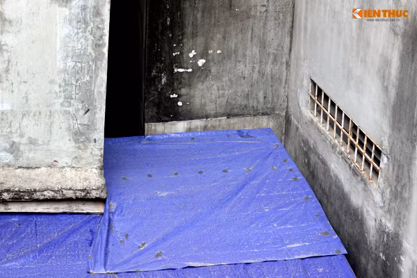 Ngôi nhà cấp 4 (số 39, bạt xanh) của gia đình anh Hiệp nằm thọt lỏm bên dưới các ngôi nhà đang bị lún nghiêng vô cùng nguy hiểm.