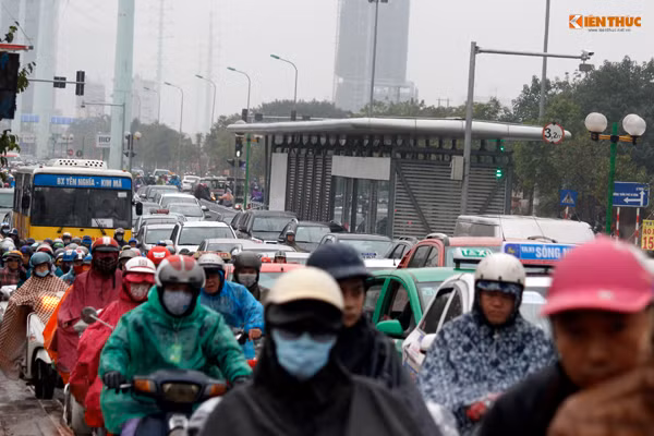 Dòng phương tiện chen chúc nhau di chuyển một cách chậm chạp qua một điểm nhà chờ xe buýt nhanh trên đường Tố Hữu.