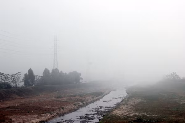 Dòng sông cạn, đen ngòm cũng trở nên huyền ảo hơn bởi hiện tượng sương mù ở Hà Nội.