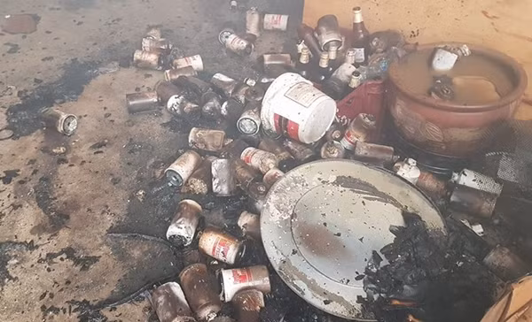 Nhiều vật dụng, chai lọ tại công ty bị lửa thiêu cháy, nằm ngổn ngang dưới nền đất.