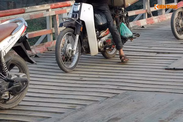 Thậm chí người dân còn phải thả hai chân xuống khỏi xe máy để "chống chèo" khi di chuyển trên cầu Chiếc.