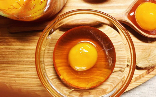 Dùng trứng gà cũng giúp phân biệt mật ong thật chính xác. Khi thực hiện, bạn chuẩn bị 1 quả trứng gà, tách lấy phần lòng đỏ cho vào tô. Tiếp đó, cho mật ong mẫu vào tô sao cho mật ong ngập hết phần lòng đỏ.