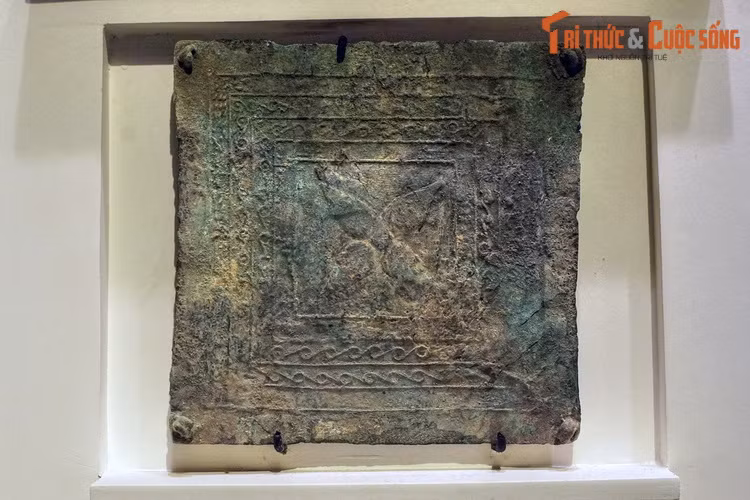 Một tấm che ngực hình vuông. Loại hình hiện vật này được trang trí cầu kỳ bằng các hoa văn đặc trưng của văn hóa Đông Sơn.